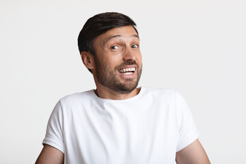 Portrait Of Confused Man Shrugging Shoulders Posing Over White Background