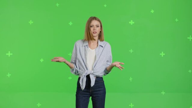 Sad upset dissatisfied irritated young woman say what is going on . Girl posing against green screen background studio. Chroma key