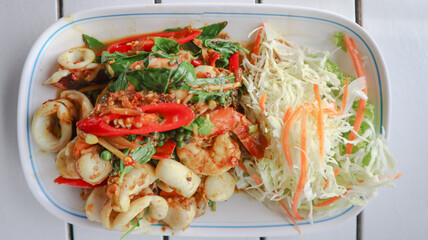 Stir fried spicy seafood aromatic Thai herb, lesser galangal, kaffir lime leaves, basil and finger chilli with flavourful seafood