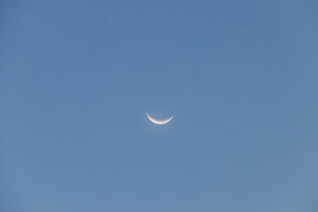 Crescent moon on blue sky. Look like a smile on a good day.
