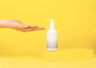 hand taking soap on yellow background