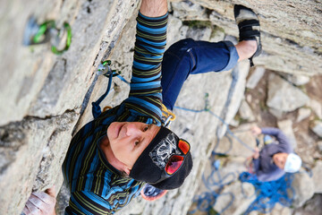A Mature climber rock climbs on a steep cliff