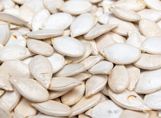 White pumpkin seeds as background.