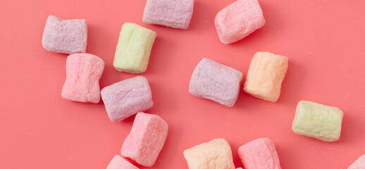 Multicolored candies on a pink background. Close-up