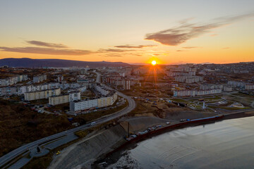 Obraz premium Aerial view of sunrise over the coastal city. Morning top view of the streets and buildings. City of Magadan, Magadan region, Siberia, Far East of Russia.