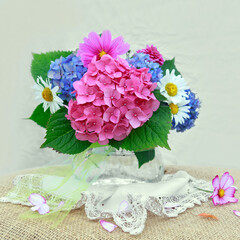 Colorful flowers bouquet in glass vase isolated on blur background.