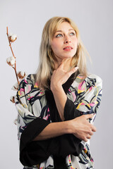 Attractive blonde woman in a black trendy and fashionable colorful kimono in a white background