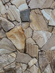 Seamless texture of medieval wall of stone blocks closely, as background wallpaper. Complete setting of the textures of the face of a smooth rock with stratum outdoors.