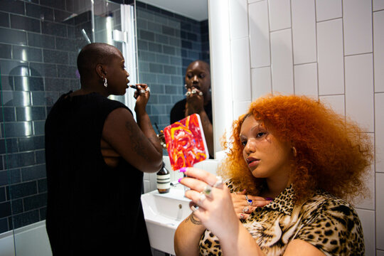 A black lesbian couple getting ready in the bathroom.
