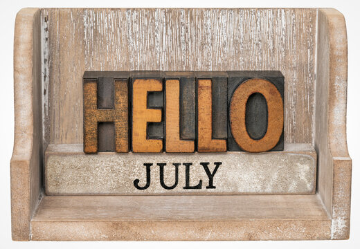 Hello July in vintage letterpress wood type inside grunge wooden box, calendar concept