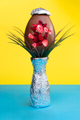 Chocolate Easter egg and decoration on vibrant blue and yellow background