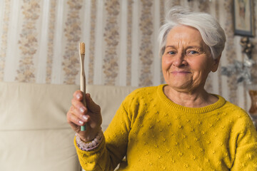 Seniors choose ecology. Friendly happy caucasian gray-haired grandmother holding ecological bamboo...