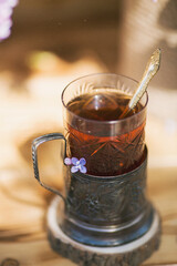 Spring. The concept of good morning. Glass coffee mug, bouquet of purple lilac on a wooden background. Still-life.The concept of good morning.