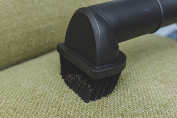 Closeup of a dusting brush nozzle attachment of a vacuum cleaner. Being used to clean the fabric...