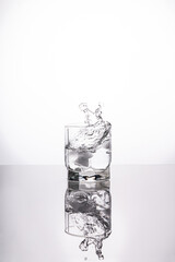 A splash of water in a glass on a light background. fresh water glass with bubbles white background