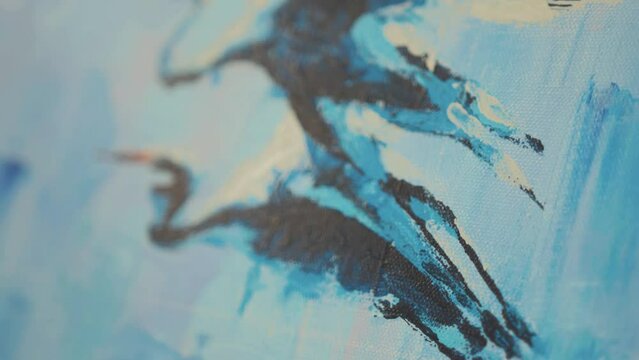 Artist applies finishing touches to hern painting with palette knife