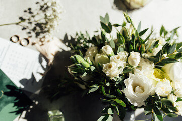 Bridal bouquet and wedding rings on window