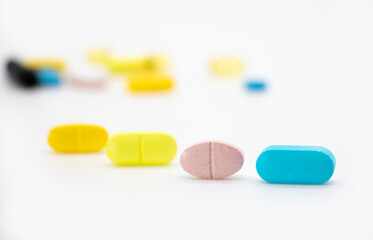 Different color pills isolate on white background, selective focus