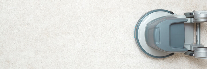 Gray professional disc machine on light beige carpet background. Closeup. Foaming and brushing...
