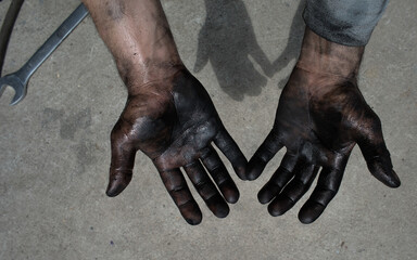 male worker hands in black oil on a gray background