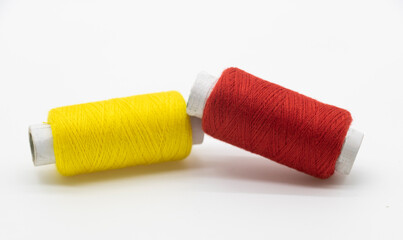 yellow and red color yarn or spool thread over on white background