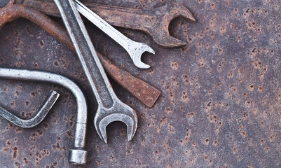 Old wrench spanner and garage tools on rusty background