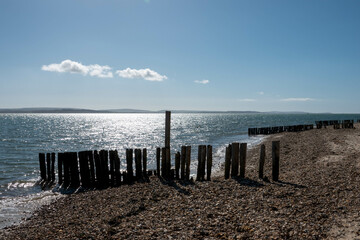 old wooden groynes on a deserted beach in England on a bright sunny spring day