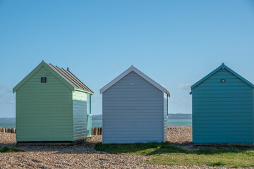 Fototapeta na wymiar coloured beach huts on the beach at Calshot Hampshire England with the sea in the background