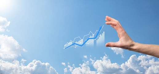 Business man holding tablet and showing holographic graphs and stock market statistics gain profits. Concept of growth planning and business strategy. Display of good economy form digital screen.
