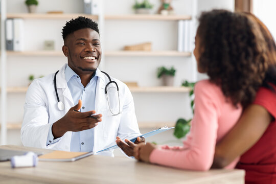 Cheerful african american doctor collecting anamnesis of patient