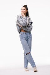 Fototapeta premium Portrait of a young woman dressed in jeans jacket standing isolated on a white background.
