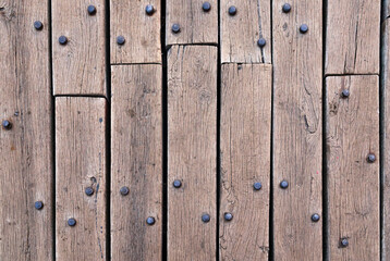 Old wooden flooring made of planks and rusty rivets.
