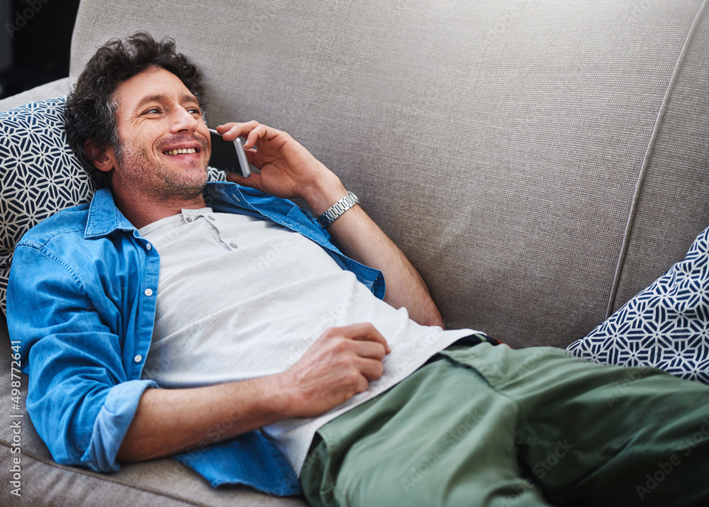 Canvas Prints Just chilling, and you. Shot of a happy bachelor answering his cellphone while relaxing on the couch at home.