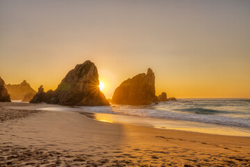 Beautiful sunset on a beach with sea stacks at the portuguese atlantic coast