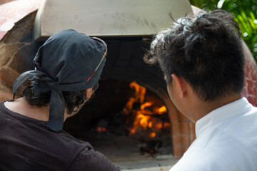 Fototapeta na wymiar chef looking for the temperature in a wood-fired oven