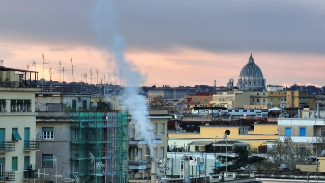 I tetti di Roma, i comignoli che fumano sullo sfondo la cupola di San Pietro
Riscaldamento, consumo del gas e inquinamento in citt&agrave;.
