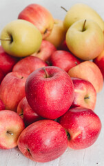 Many eco red apples on white wooden table. Healthy eating concept.