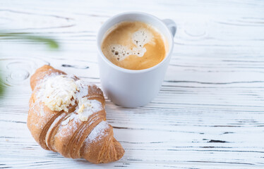 croissant and a cup of coffee on a white background