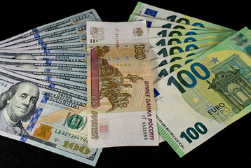 One hundred dollar, ruble, euro banknotes. On a black background