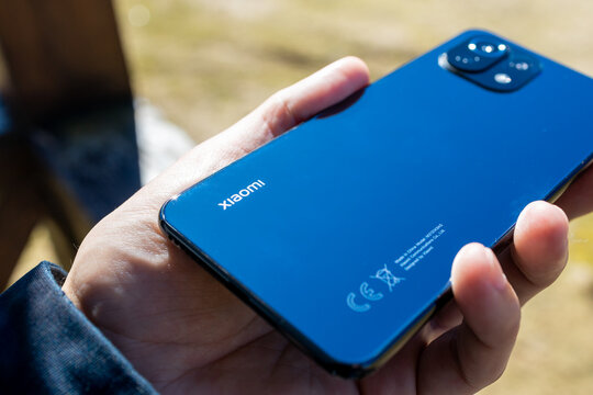 Lviv, Ukraine - 13 April 2022: Xiaomi mi 11 lite smartphone illustrative editorial. person showing xiaomi brand logo. outdoors