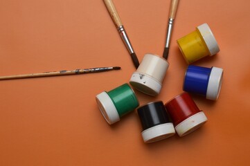 Multicolor watercolor paints and brushes on the surface of the material