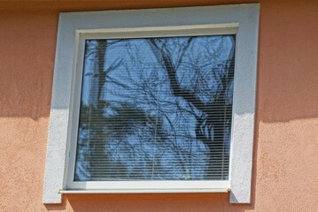 one white square large window on the brown concrete wall of the building