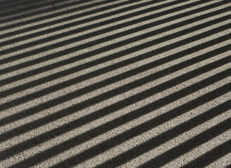 texture of shadows of a grating on asphalt
