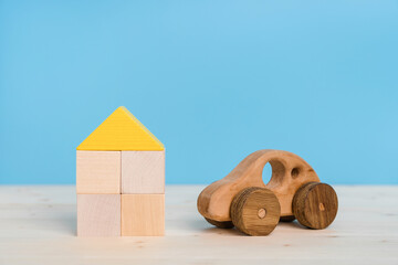 The concept of car and real estate insurance. wooden toy car and house made of toy wooden blocks on...