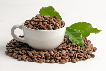 Coffee bean medium roasted in cup with leaf in fresh morning isolated on white background.