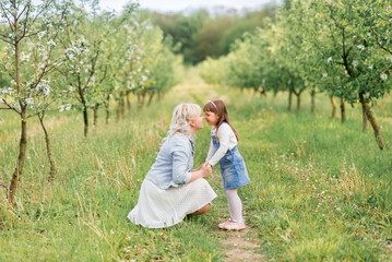 walk in the spring garden of a mother with a little daughter