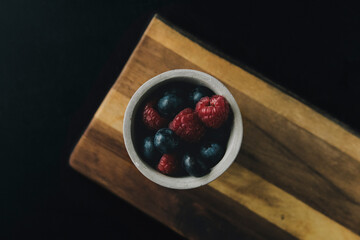 bowl of berries on a wooden board