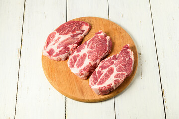Sliced raw pork meat on wooden surface, top view