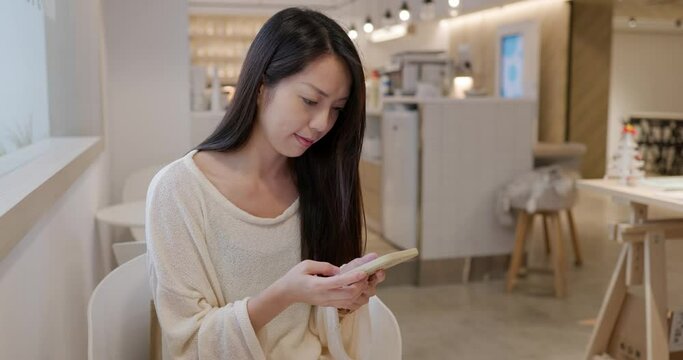 Woman use mobile phone inside coffee shop