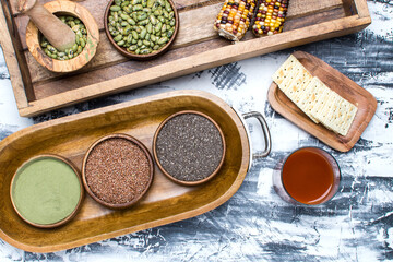 chia, flax seeds and other healthy seeds in wooden bowls.